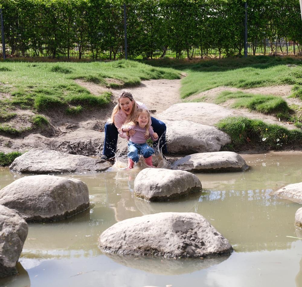Pedagogisch professional en meisje stappen in het water