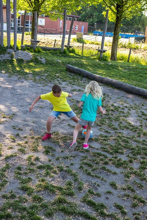 twee kinderen voetballen samen