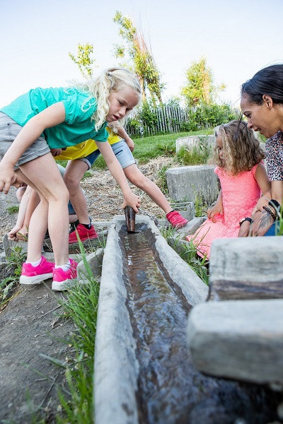 Kinderen spelen buiten met de waterbaan