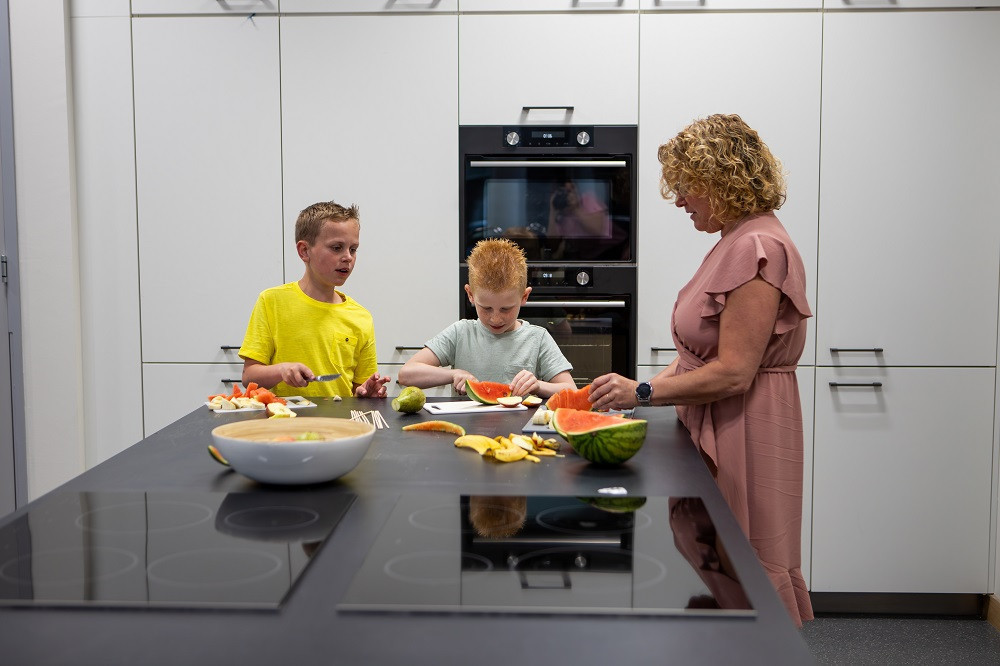 kinderen snijden fruit met pedagogisch medewerker
