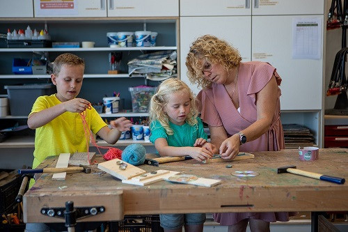 Pedagogisch medewerker en kinderen knutselen