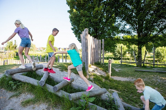 BSO kinderen spelen buiten in de natuur- ontdektuin