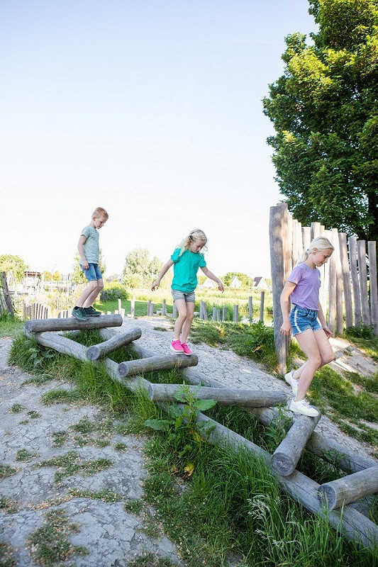 BSO kinderen spelen buiten in de natuur- en ontdektuin