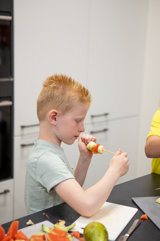 jongen maakt fruitspies