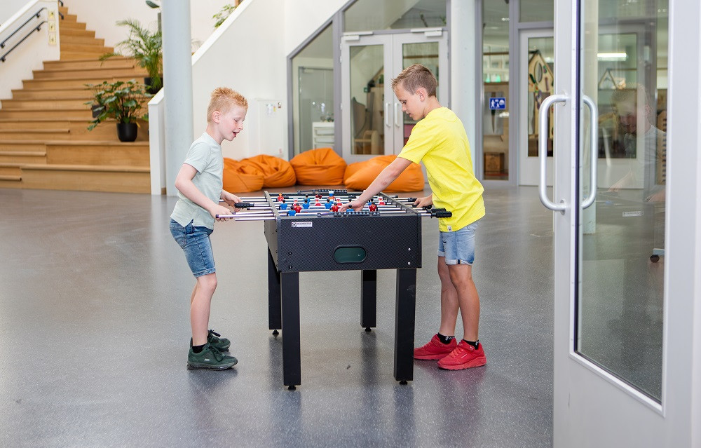 twee jongens spelen tafelvoetbal