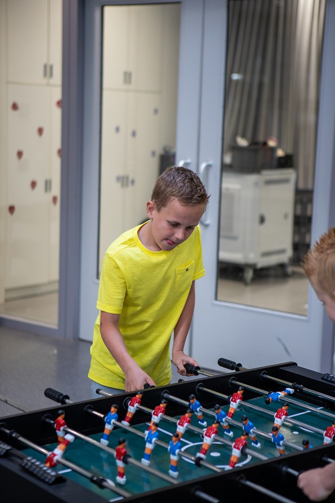 jongen is geconcentreerd aan het tafelvoetballen