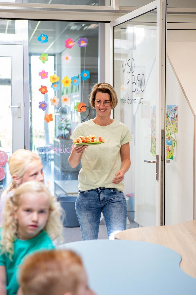 Pedagogisch medewerker heeft een bordje met fruit