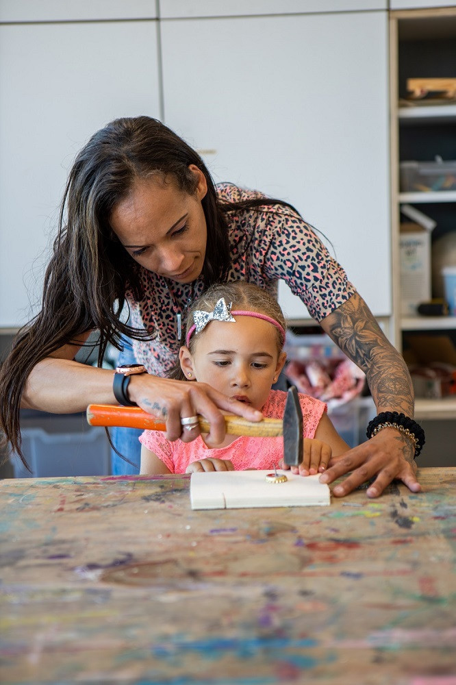pedagogisch medewerker en meisje timmeren