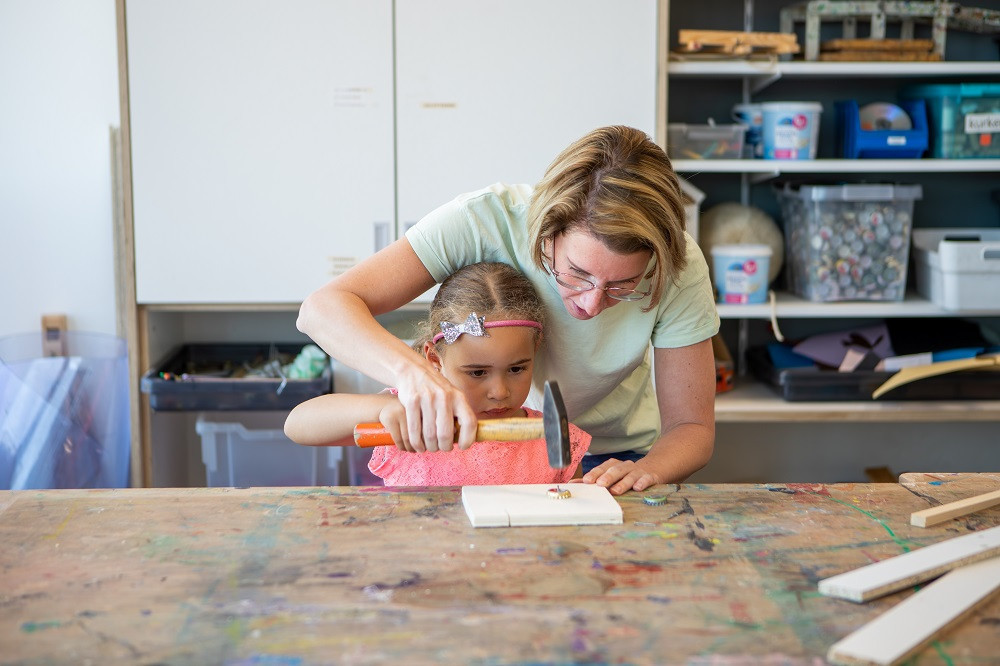 pedagogisch medewerker en meisje timmeren samen
