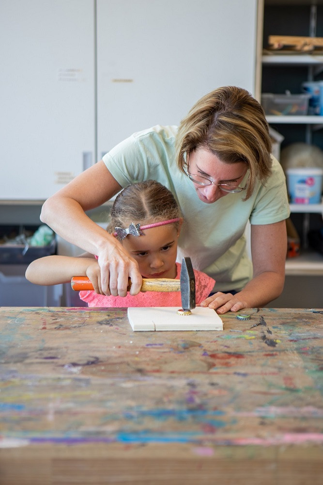 pedagogisch medewerker en meisje timmeren samen