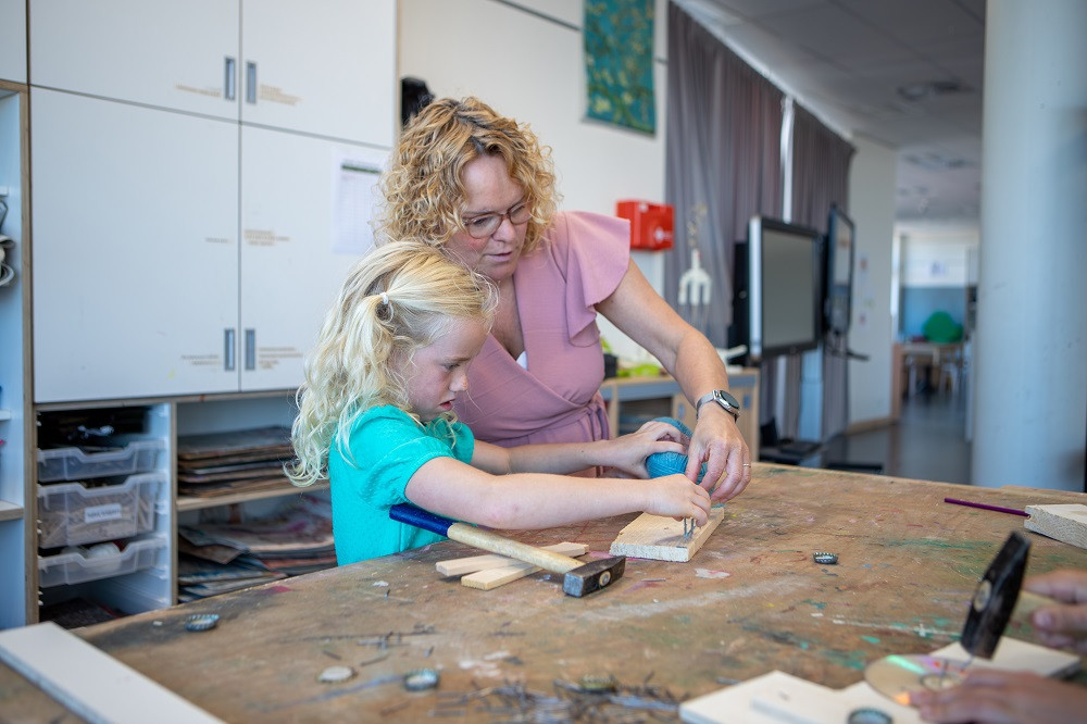 pedagogisch medewerker en meisje timmeren samen