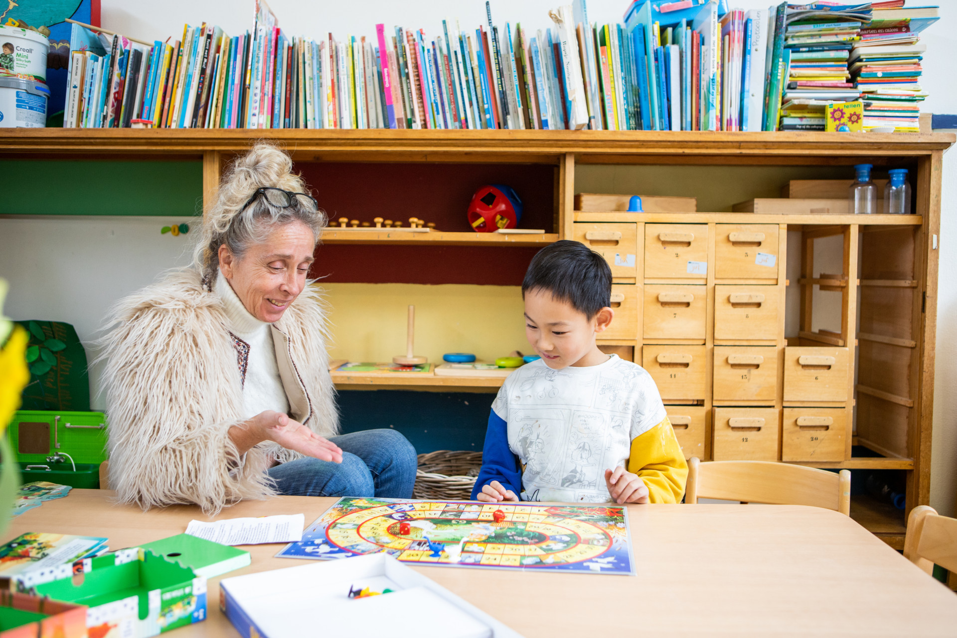 pedagogisch medewerker en kind spelen spel
