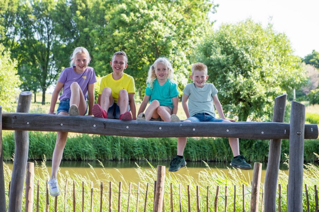 BSO kinderen zitten op een balk