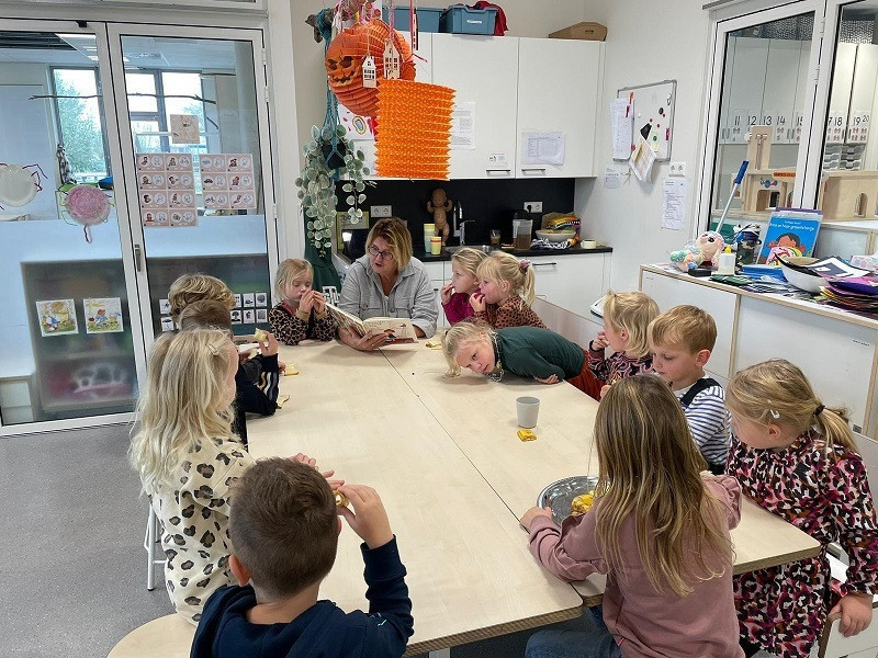 Pedagogisch professional leest voor aan groep kinderen