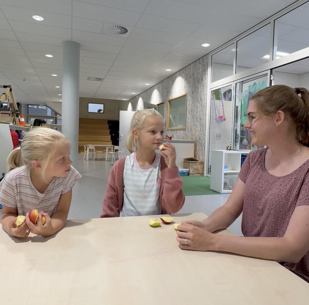 Pedagogisch professional Robin met twee meisjes aan tafel