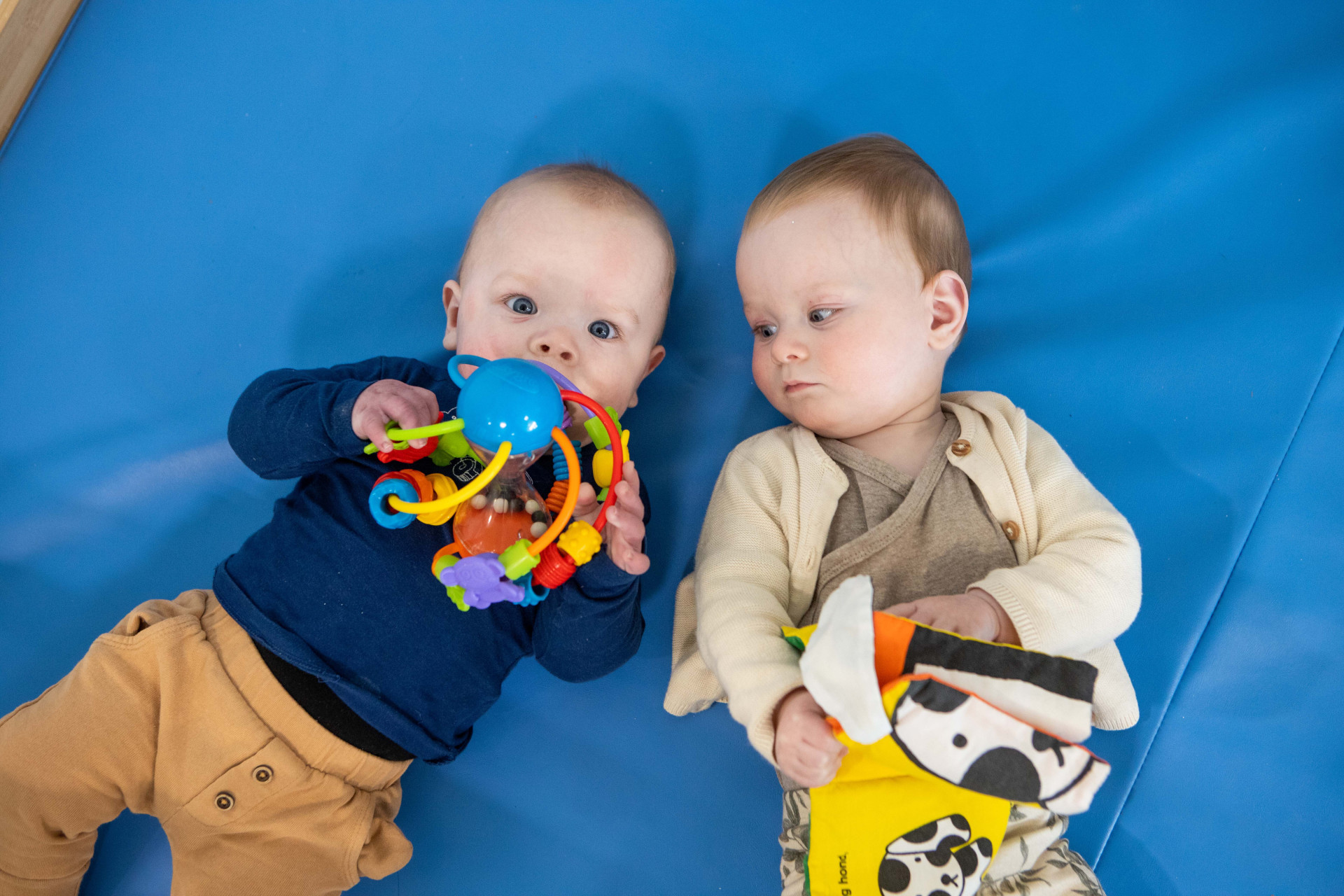 twee baby's spelen samen op de grond