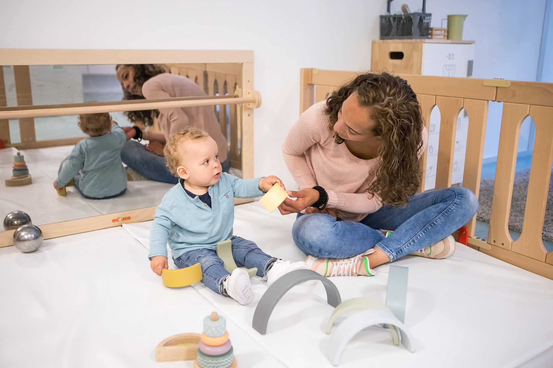 pedagogisch medewerker en dreumes spelen in de grondbox