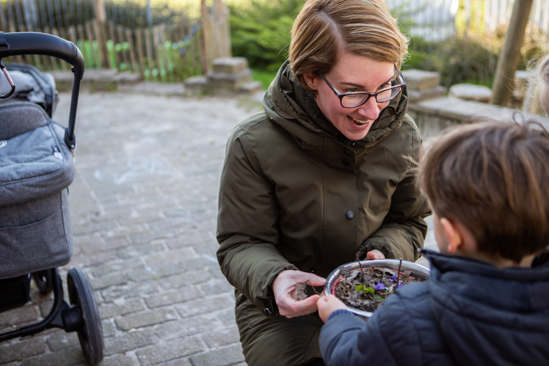 pedagogisch medewerker speelt buiten met peuter
