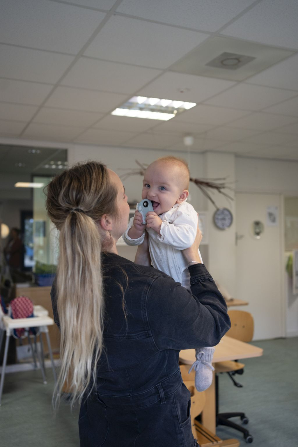 pedagogisch professional houdt baby omhoog