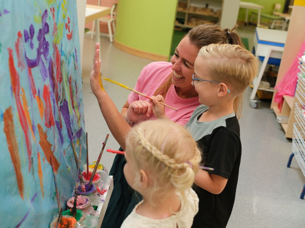 kind verft de hand van de pedagogisch professional geel