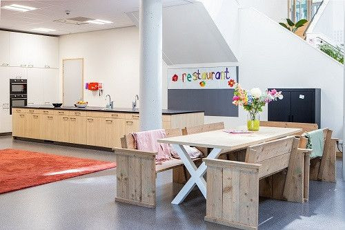 Grote keuken met lang kookeiland en tafel met houten banken