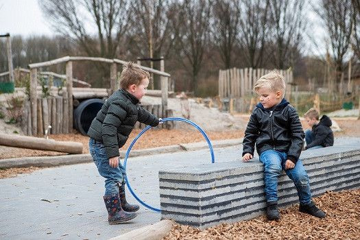 twee jongetjes spelen buiten met hoepel