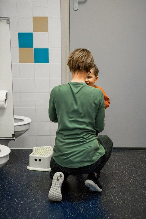 pedagogisch professional helpt kind naar de wc