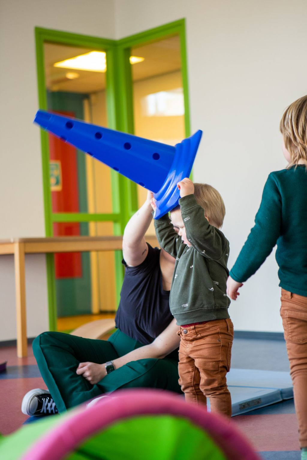 pedagogisch professional helpt kind met pion op hoofd krijgen