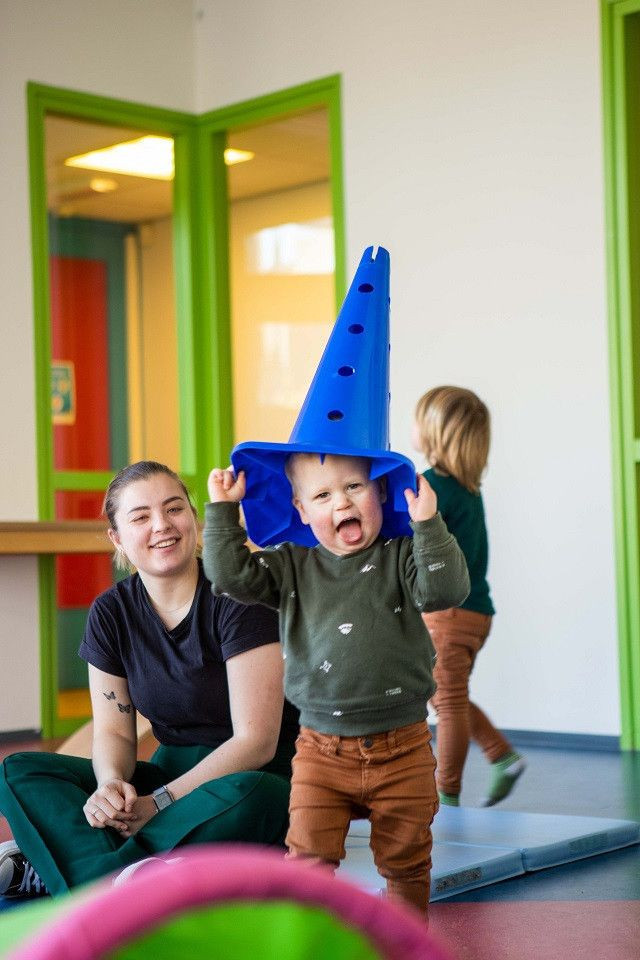 kind met pion op zijn hoofd steekt tong uit