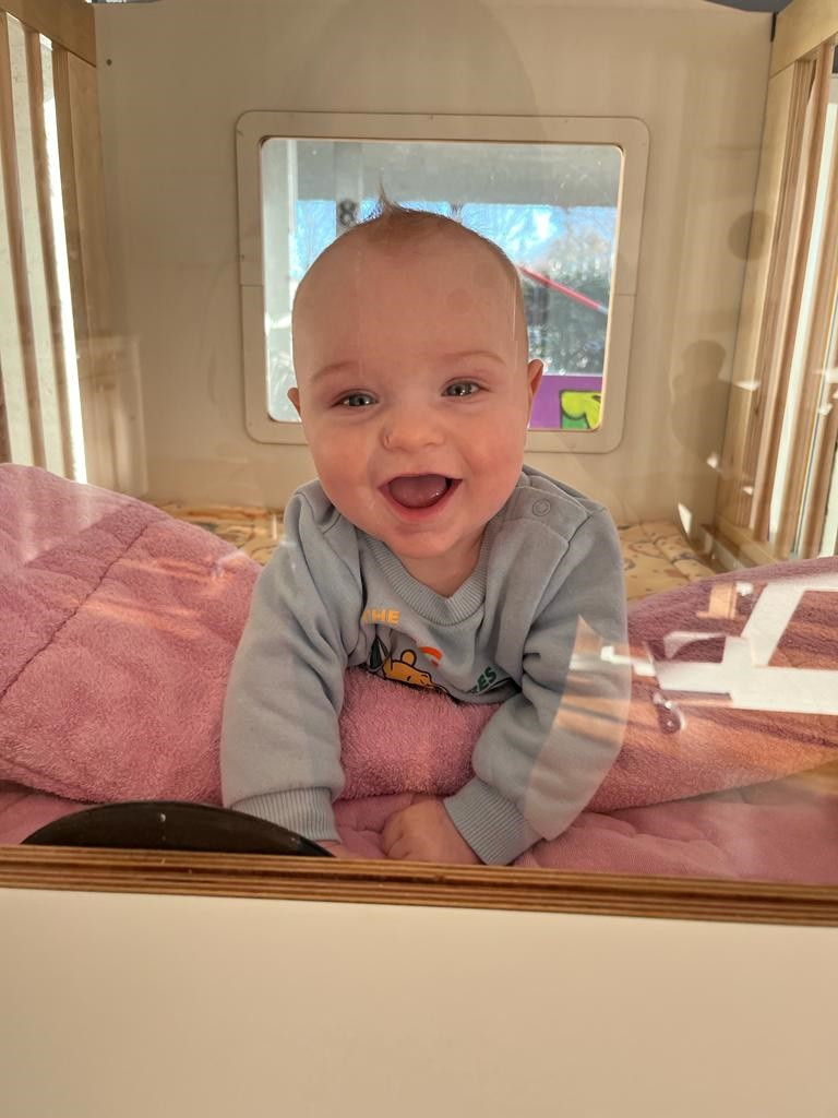 Baby lachend in de box