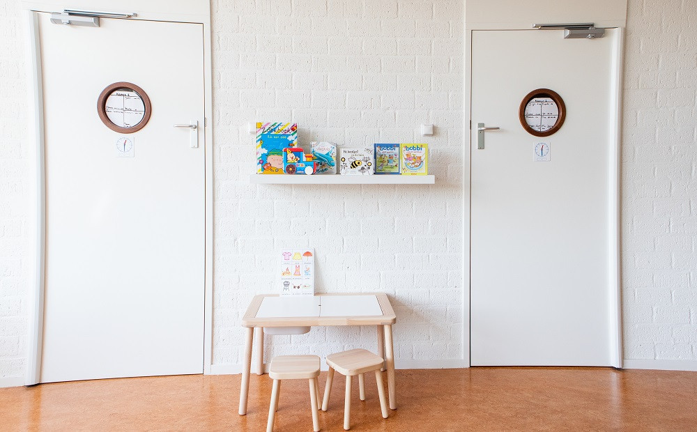 kleine tafel met stoelen en boeken op plank