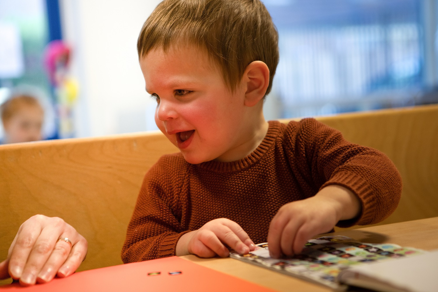 jongen kijkt blij en plakt stickers
