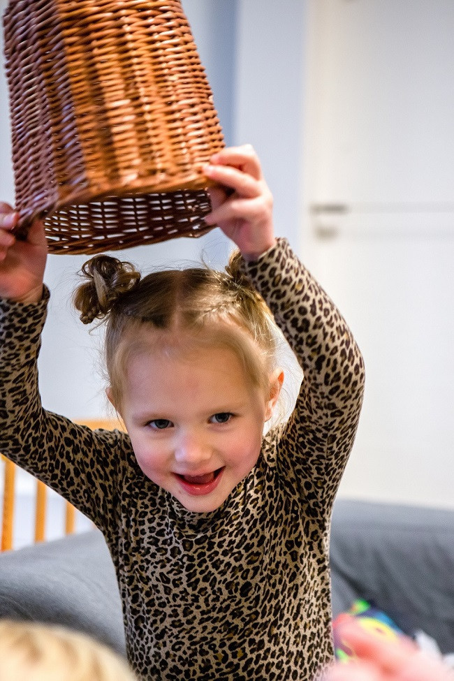 meisje houdt rietenmand op zijn kop boven haar hoofd