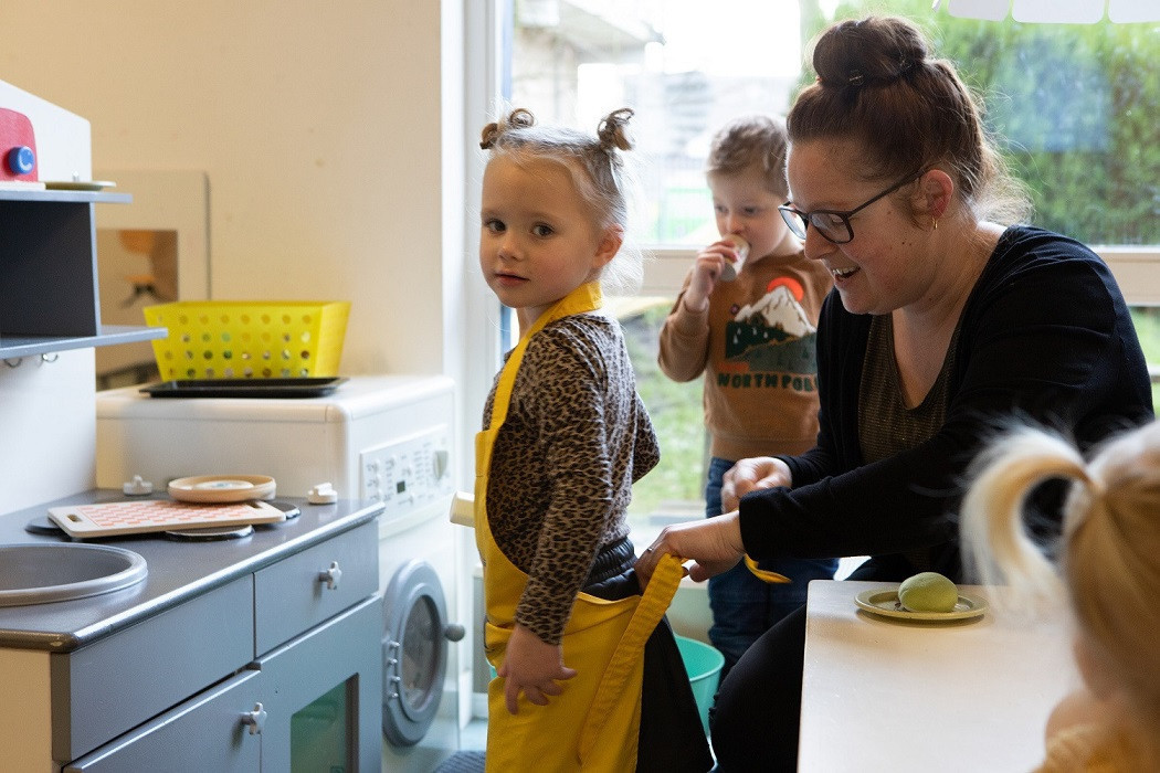 Pedagogisch professional strikt het kookschort van een meisje