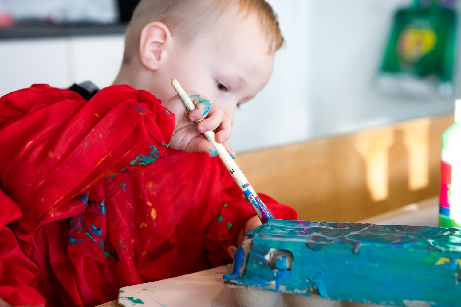 jongen verft eierdoos met blauwe verf