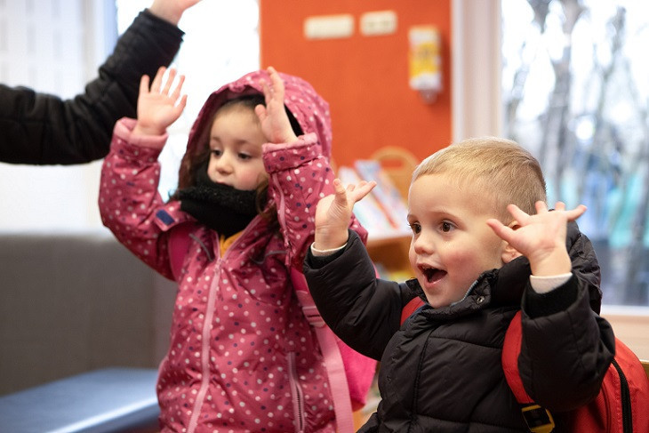 Kinderen steken de handen in de lucht