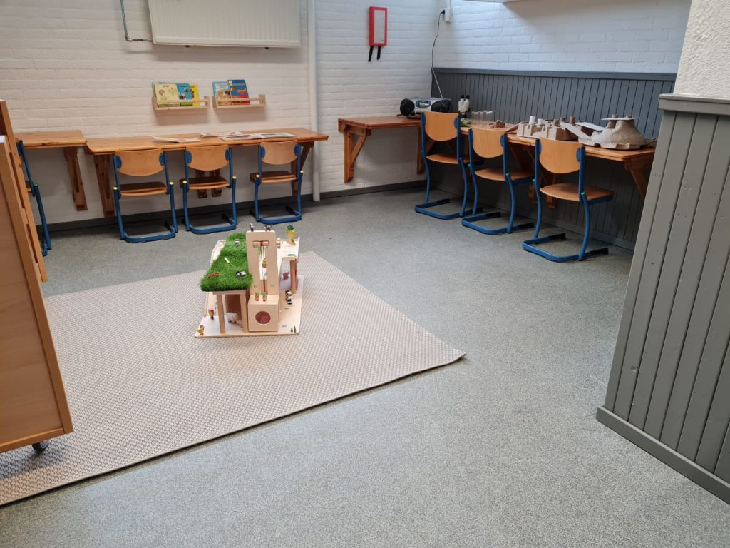 lokaal met tafels tafels aan wand met stoelen