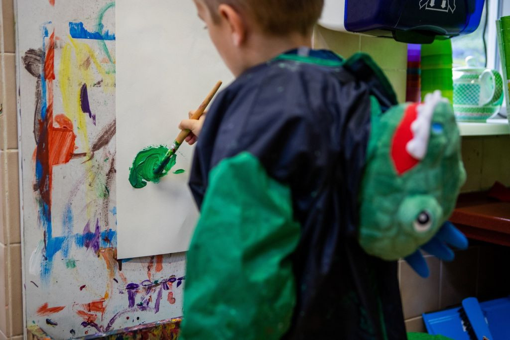 jongen met dinopak verft met groene verf