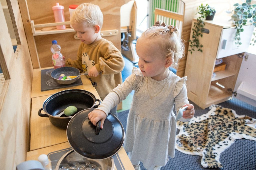 Twee kinderen koken samen in speelgoedkeuken