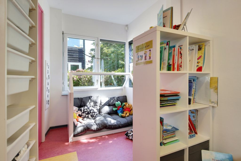 leeshoek met kussens, knuffels en een boekenkast