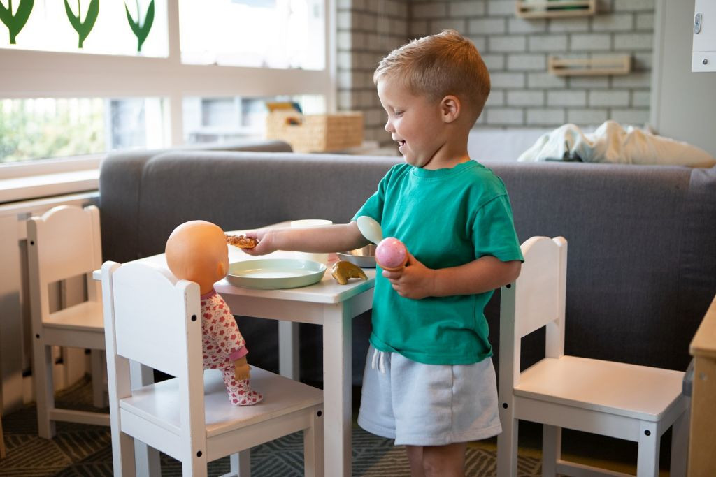 jongetje geeft pop eten