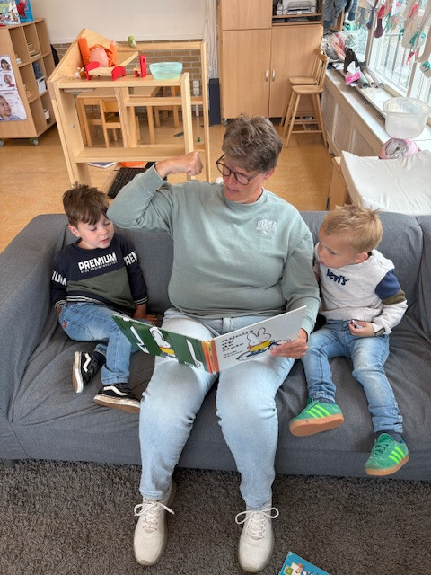 Pedagogisch professional Mirjam leest voor aan twee jongens