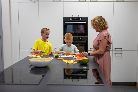 kinderen snijden fruit met pedagogisch medewerker
