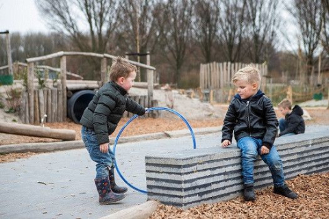 twee jongetjes spelen buiten met hoepel