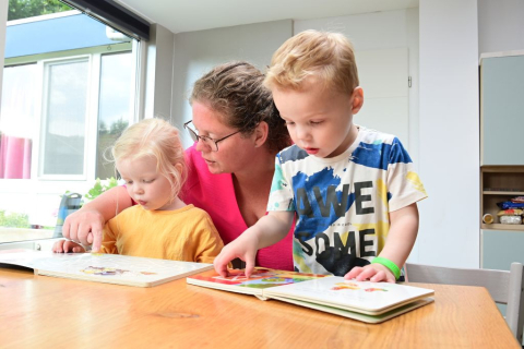 gastouder leest met twee kinderen
