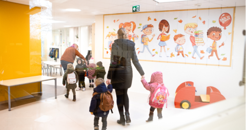 pedagogisch medewerkers lopen met peuters naar buiten
