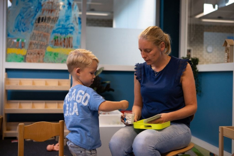 Pedagogisch professional en jongetje spelen een spelletje