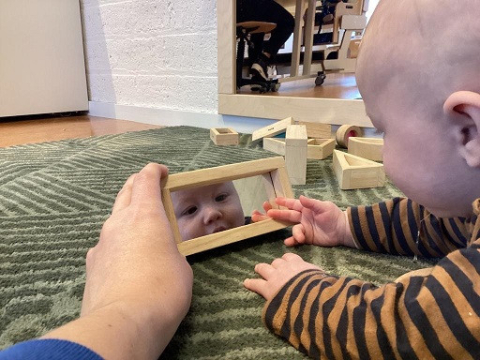 Baby kijkt in de spiegel