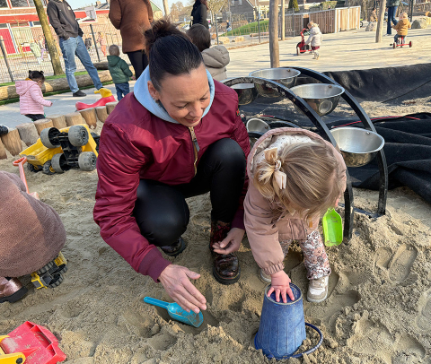 Pm'er Anjo met kinderen in de zandbak