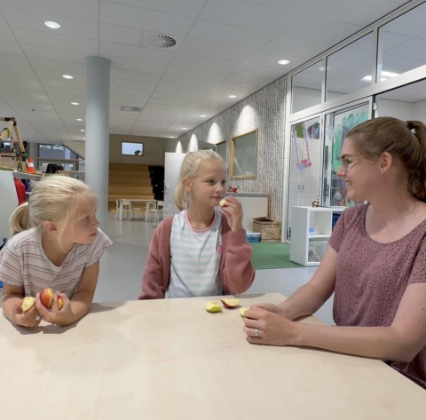 Pedagogisch professional Robin met twee meisjes aan tafel